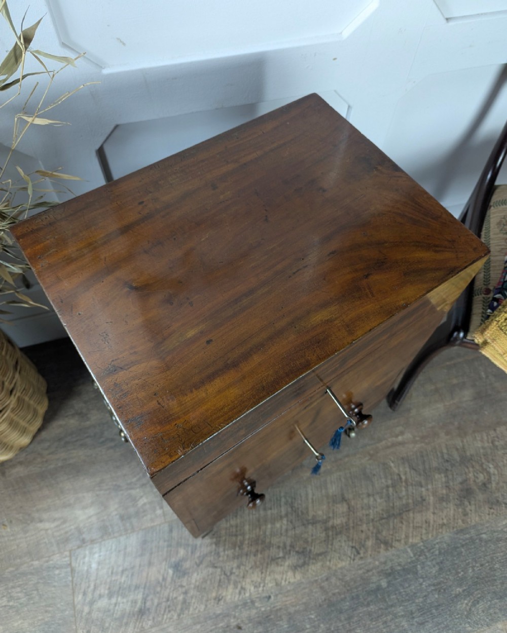 A Georgian dark mahogany cellarette featuring a hinged top lid, a lower drawer with wooden turned knobs, brass side handles, and square tapered legs on brass castors. View VIII