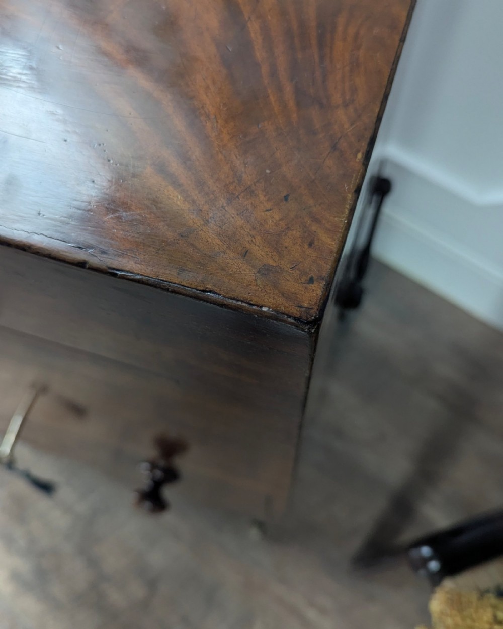 A Georgian dark mahogany cellarette featuring a hinged top lid, a lower drawer with wooden turned knobs, brass side handles, and square tapered legs on brass castors. View XI