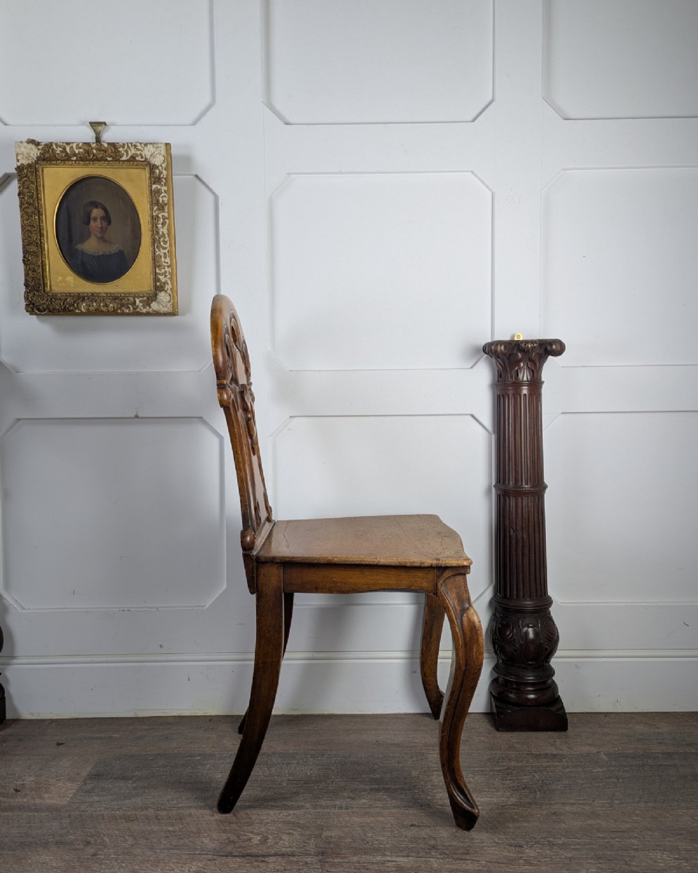A Victorian carved solid oak hall chair featuring an openwork shield back, a solid timber seat, and shaped cabriole front legs. View VIII