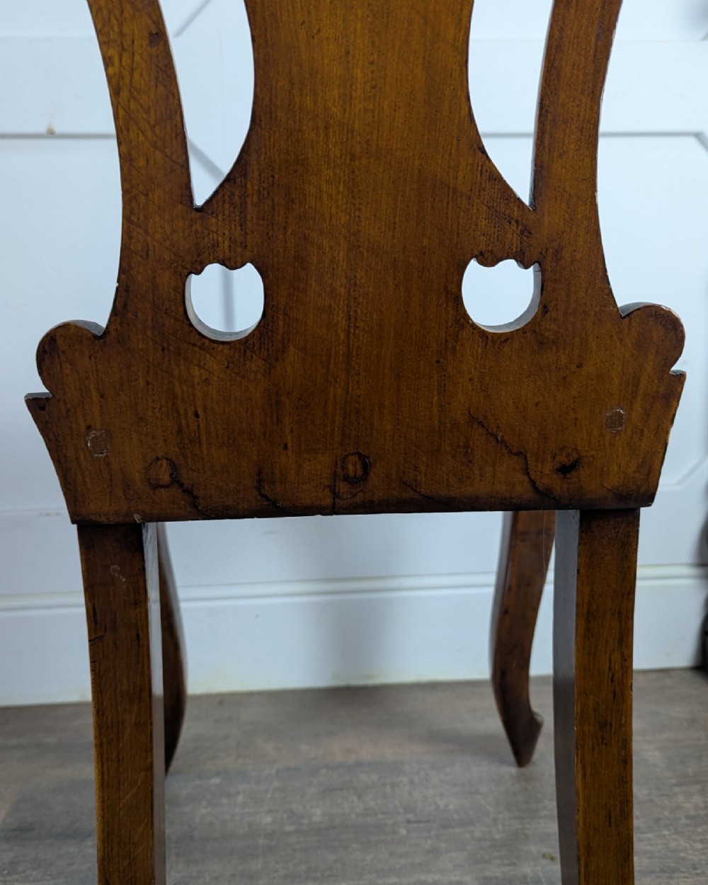 A Victorian carved solid oak hall chair featuring an openwork shield back, a solid timber seat, and shaped cabriole front legs. View XI