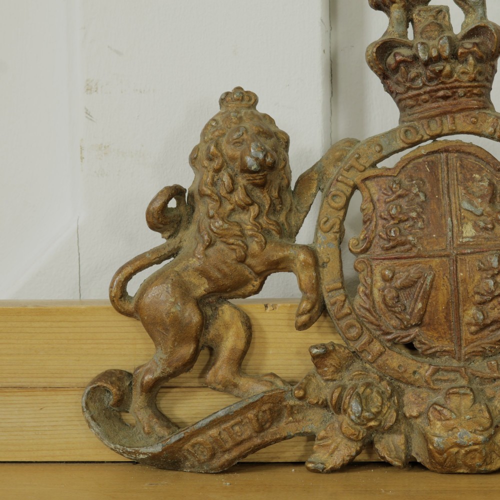 A Victorian cast metal relief plaque depicting the Royal Coat of Arms of the United Kingdom flanked by a lion and unicorn. View II