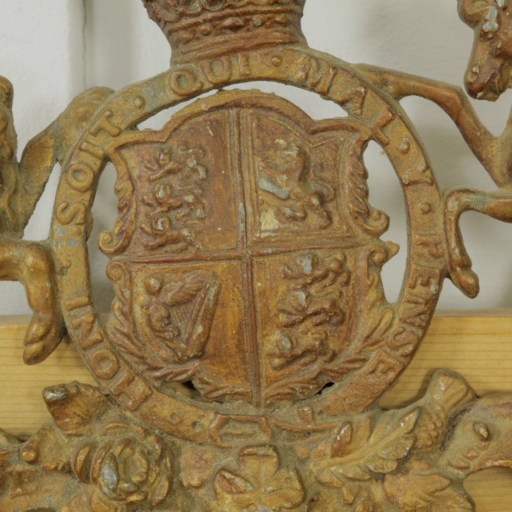 A Victorian cast metal relief plaque depicting the Royal Coat of Arms of the United Kingdom flanked by a lion and unicorn. View V