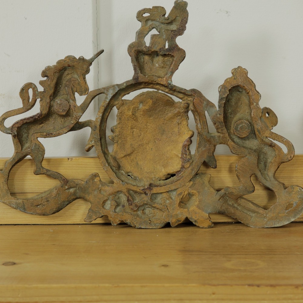 A Victorian cast metal relief plaque depicting the Royal Coat of Arms of the United Kingdom flanked by a lion and unicorn. View VII