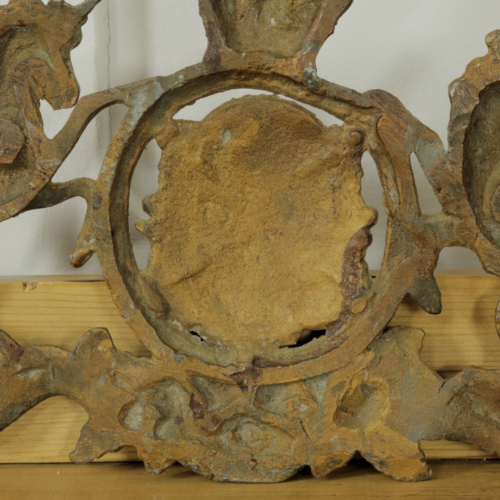 A Victorian cast metal relief plaque depicting the Royal Coat of Arms of the United Kingdom flanked by a lion and unicorn. View VIII