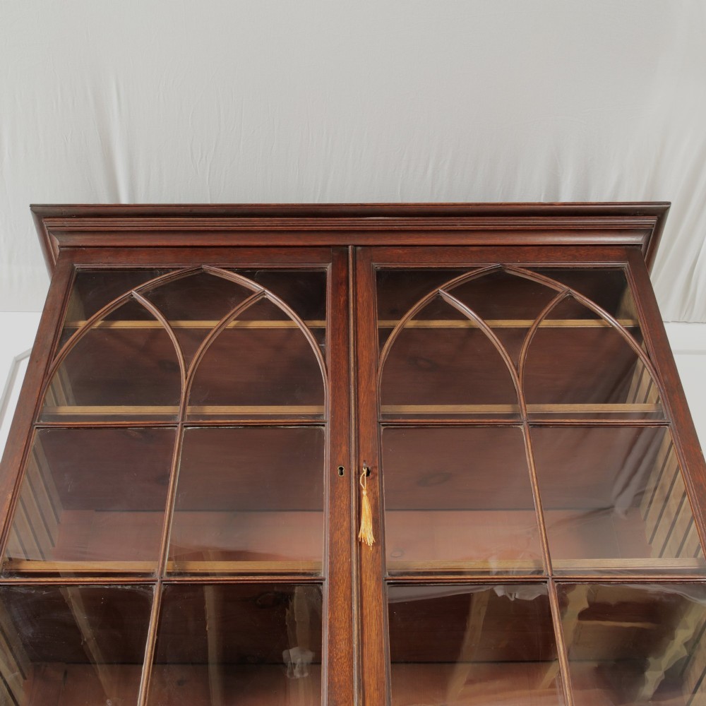 A 19th-century mahogany secretaire bookcase featuring an upper glazed cabinet with gothic arch doors and a lower chest of drawers. View VIII
