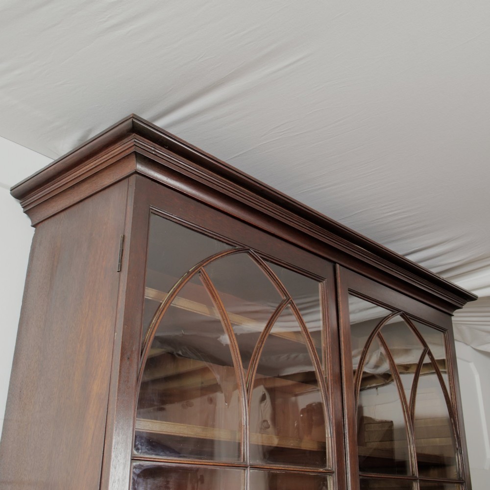 A 19th-century mahogany secretaire bookcase featuring an upper glazed cabinet with gothic arch doors and a lower chest of drawers. View X