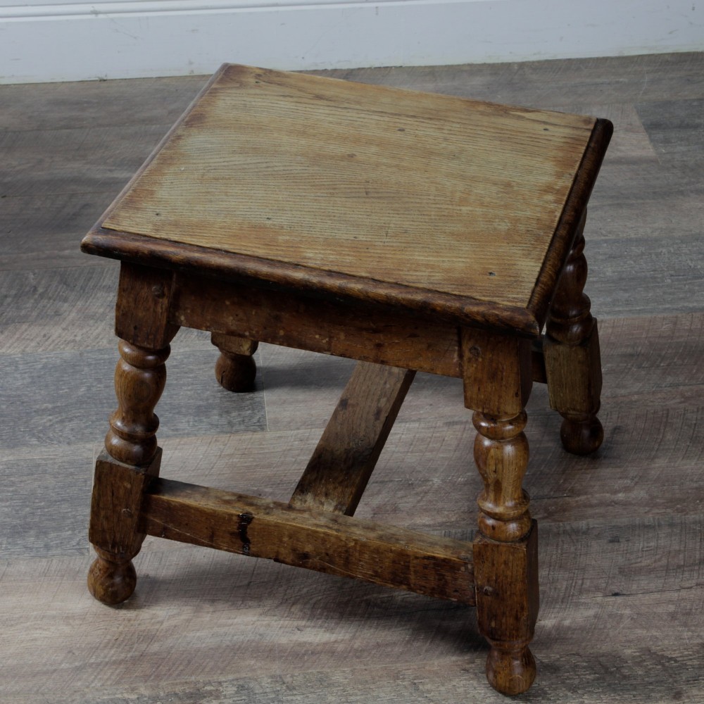 A pair of 19th-century oak joint stools featuring square tops, turned baluster legs, pegged joinery, and low perimeter stretchers. View V