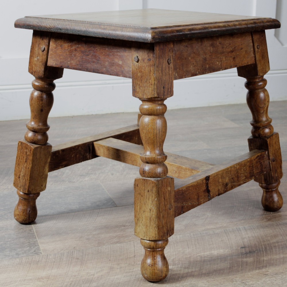 A pair of 19th-century oak joint stools featuring square tops, turned baluster legs, pegged joinery, and low perimeter stretchers. View VI