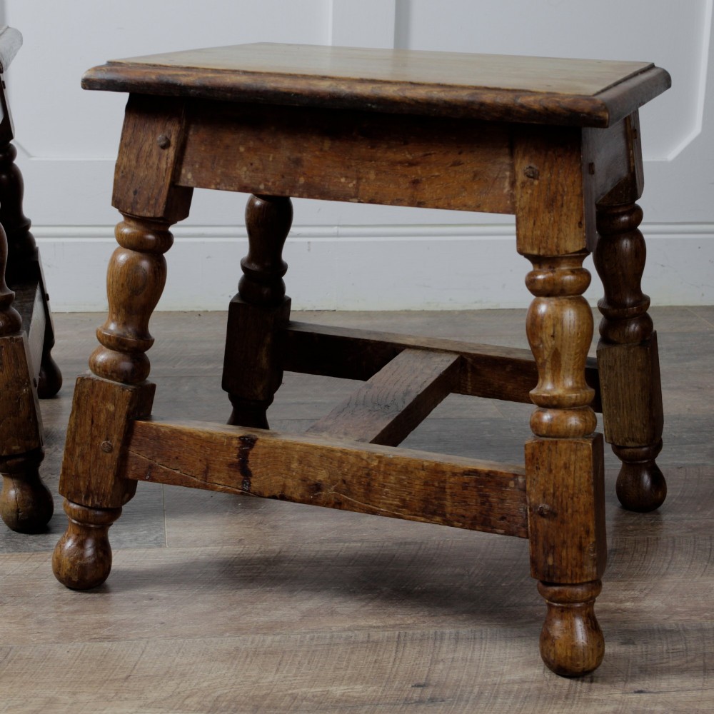 A pair of 19th-century oak joint stools featuring square tops, turned baluster legs, pegged joinery, and low perimeter stretchers. View VII