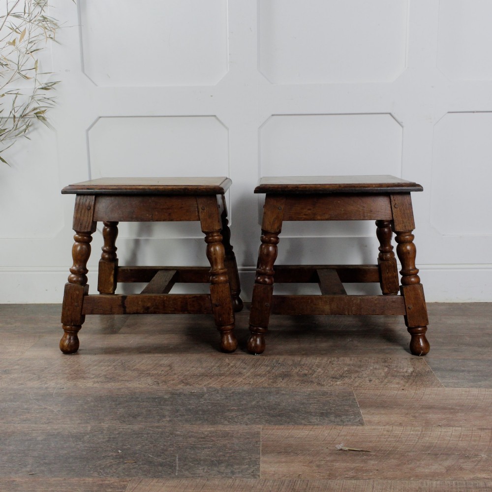 A pair of 19th-century oak joint stools featuring square tops, turned baluster legs, pegged joinery, and low perimeter stretchers. View X