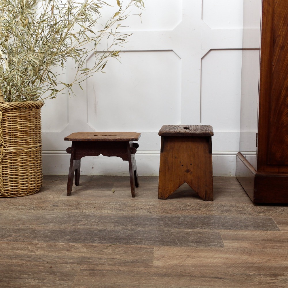 A pair of small 19th-century wooden country stools constructed from dark oak and pine with cut-out trestle legs. View V