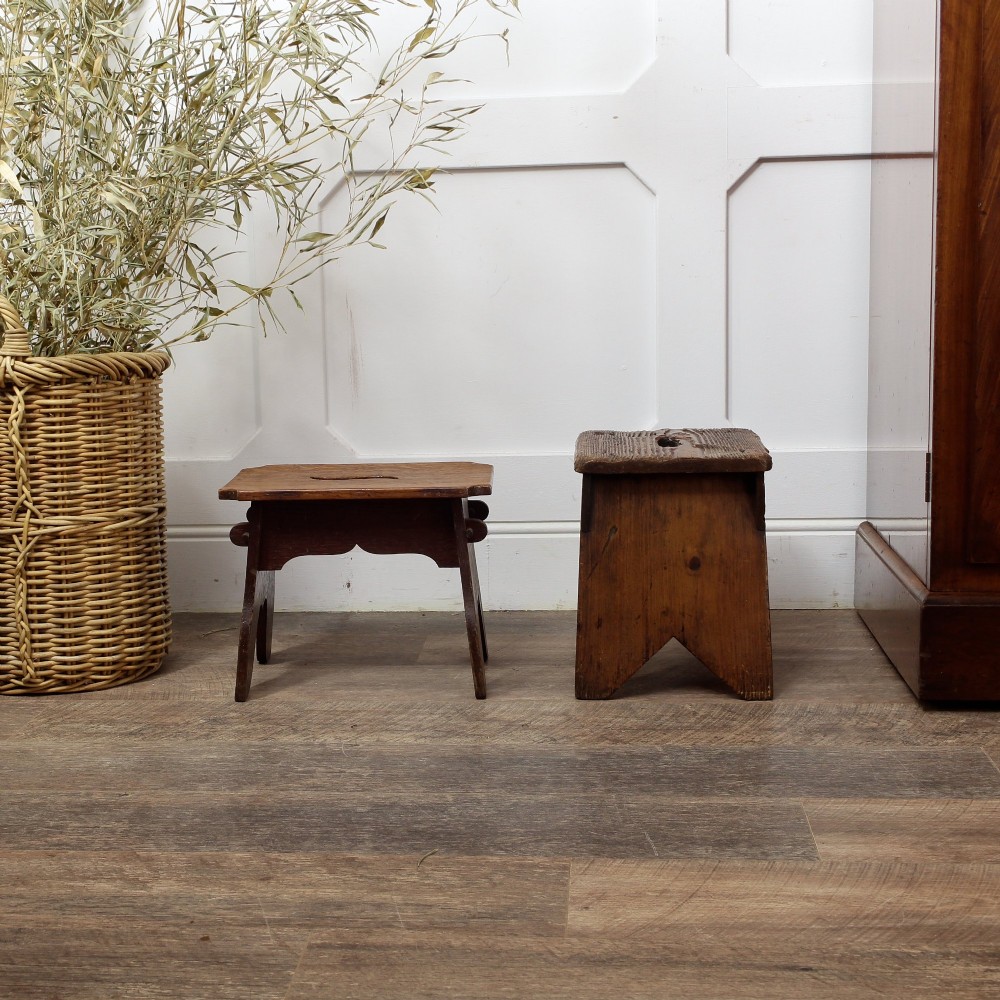 A pair of small 19th-century wooden country stools constructed from dark oak and pine with cut-out trestle legs. View VII