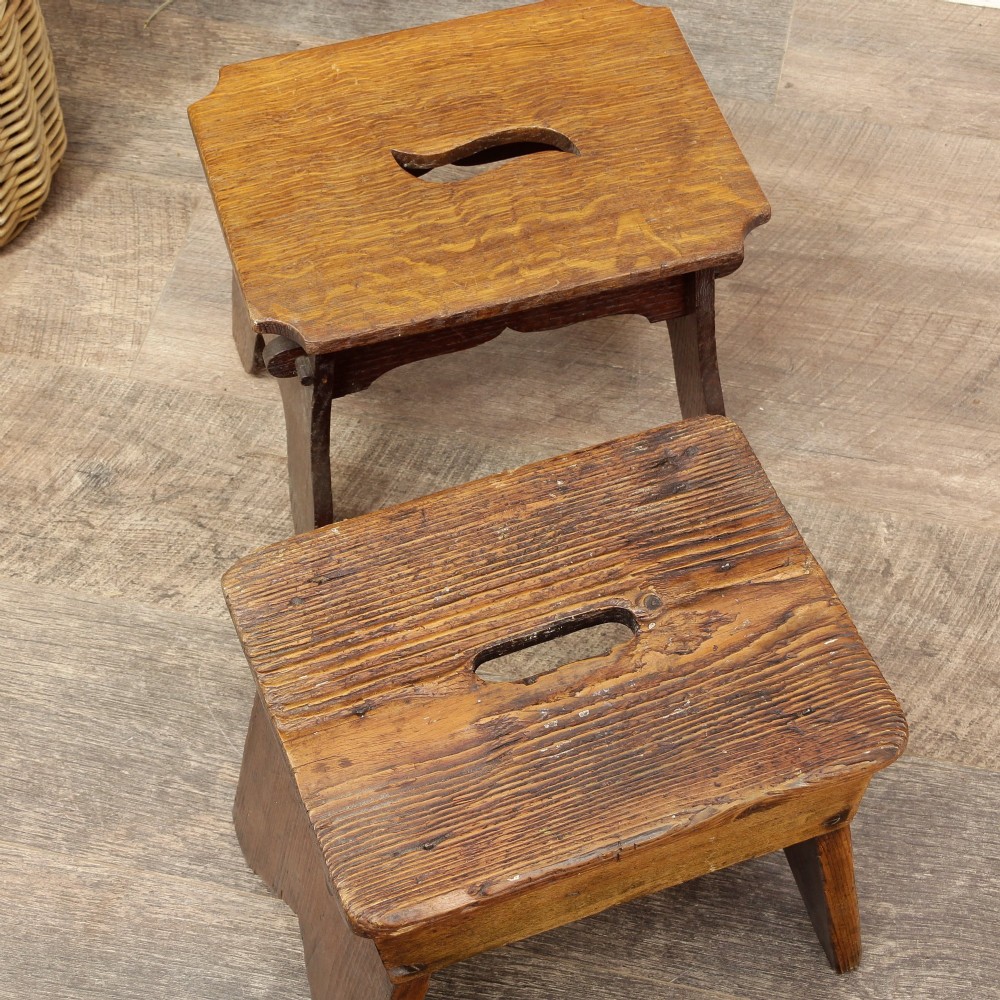 A pair of small 19th-century wooden country stools constructed from dark oak and pine with cut-out trestle legs. View X