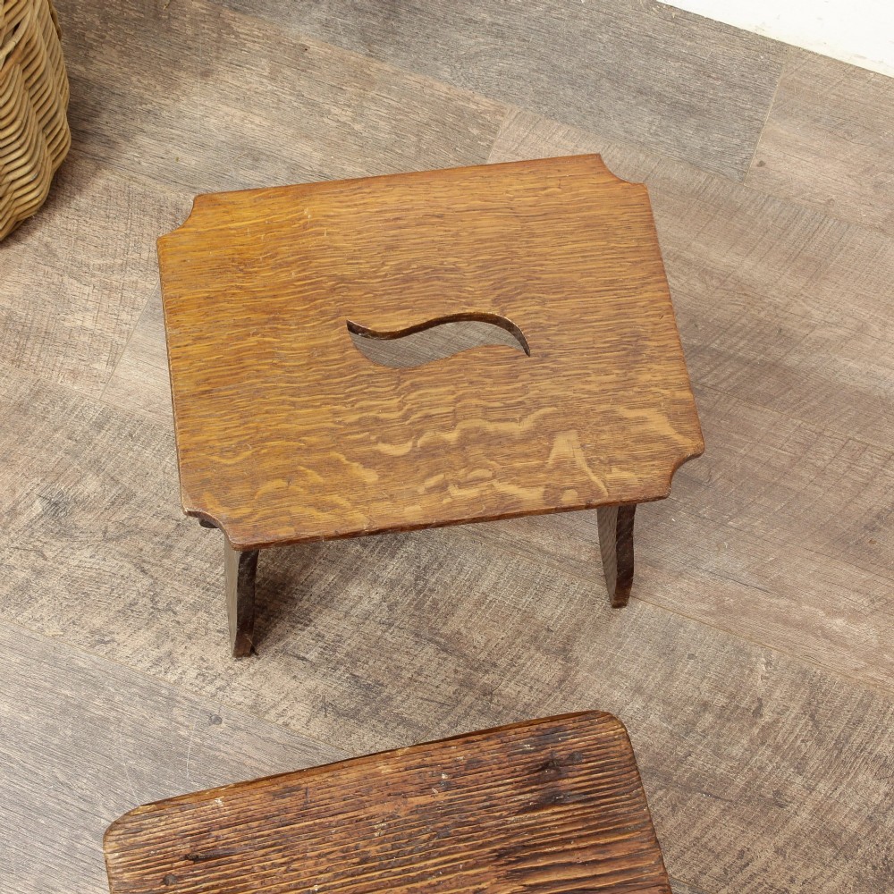 A pair of small 19th-century wooden country stools constructed from dark oak and pine with cut-out trestle legs. View XIV
