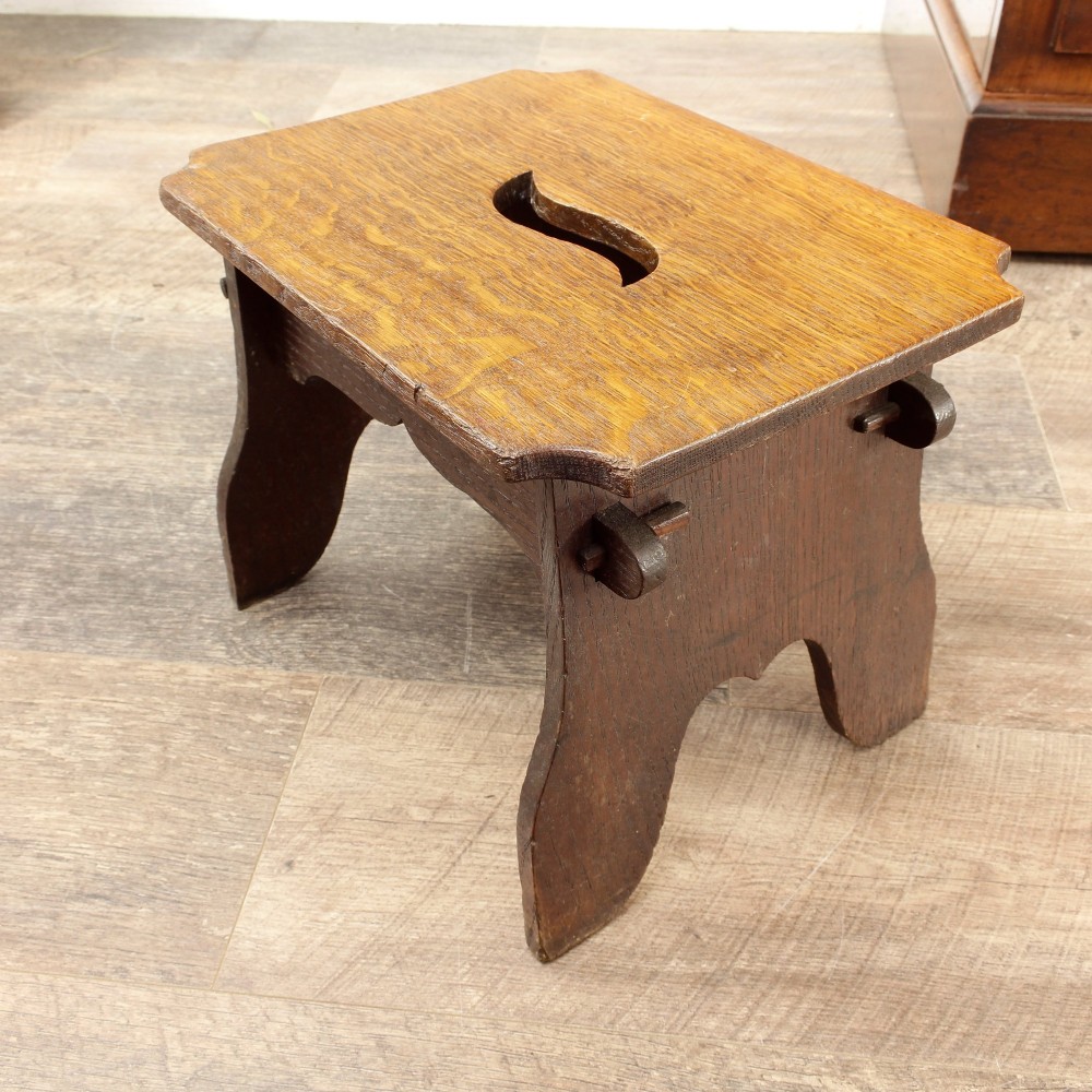 A pair of small 19th-century wooden country stools constructed from dark oak and pine with cut-out trestle legs. View XV