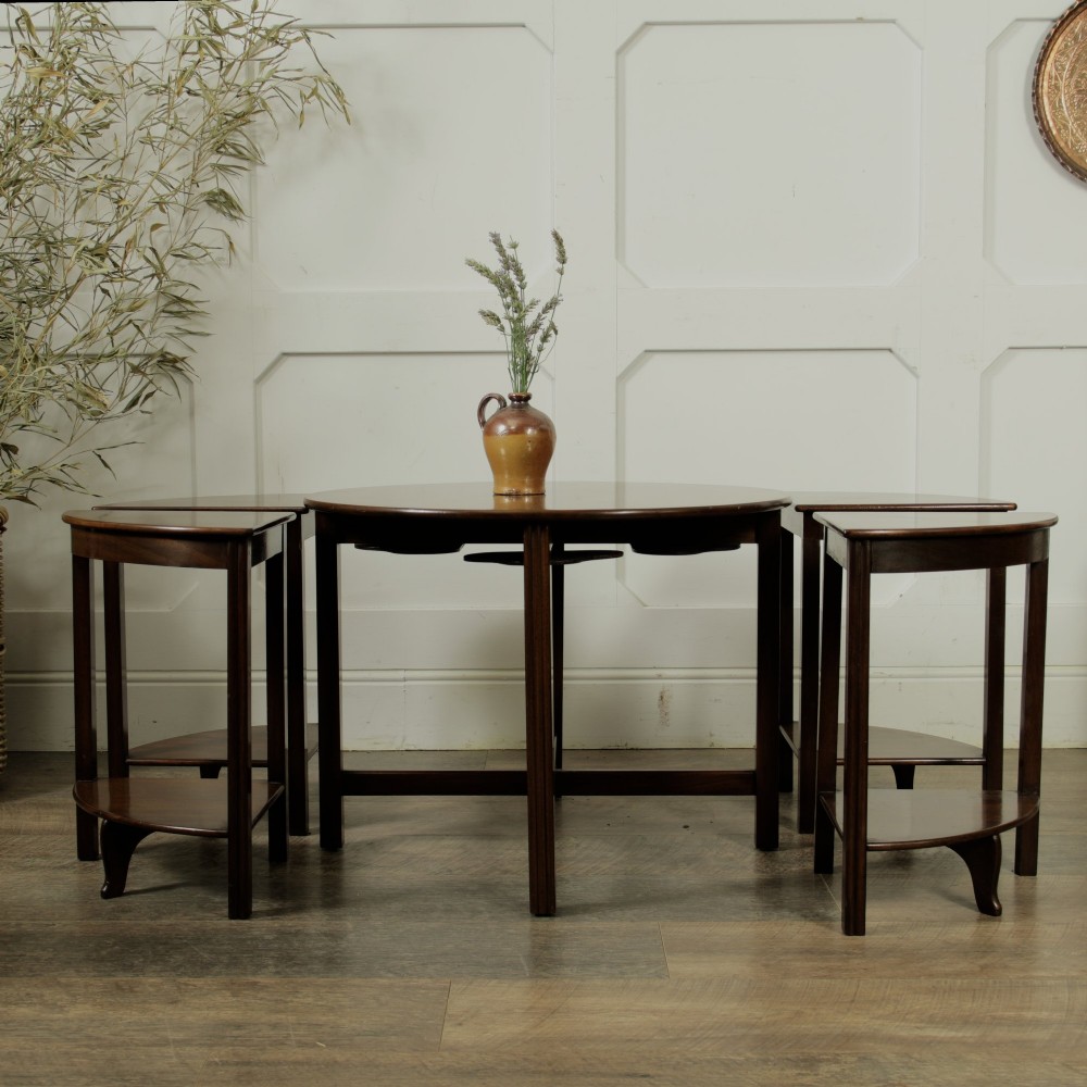 An Edwardian mahogany nest of five circular tables featuring four individual quarter-circle side tables stacked beneath the central round table. View V