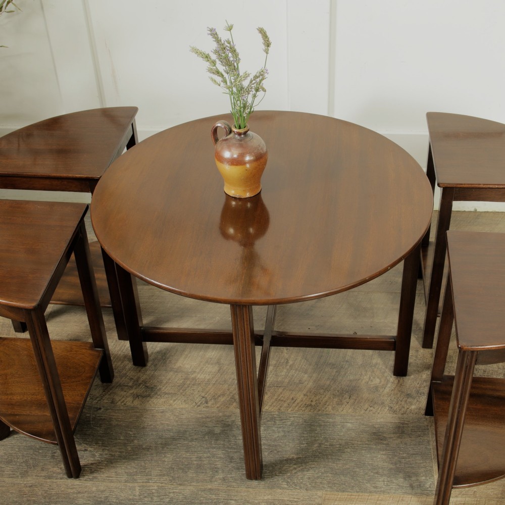 An Edwardian mahogany nest of five circular tables featuring four individual quarter-circle side tables stacked beneath the central round table. View VI