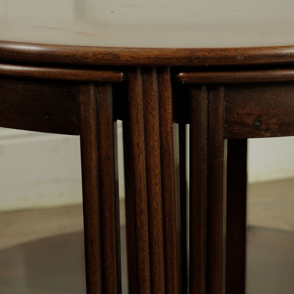 An Edwardian mahogany nest of five circular tables featuring four individual quarter-circle side tables stacked beneath the central round table. View VII