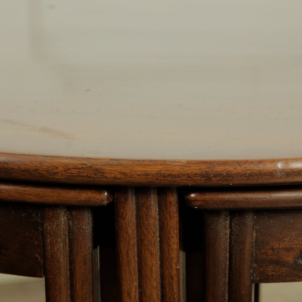 An Edwardian mahogany nest of five circular tables featuring four individual quarter-circle side tables stacked beneath the central round table. View VIII