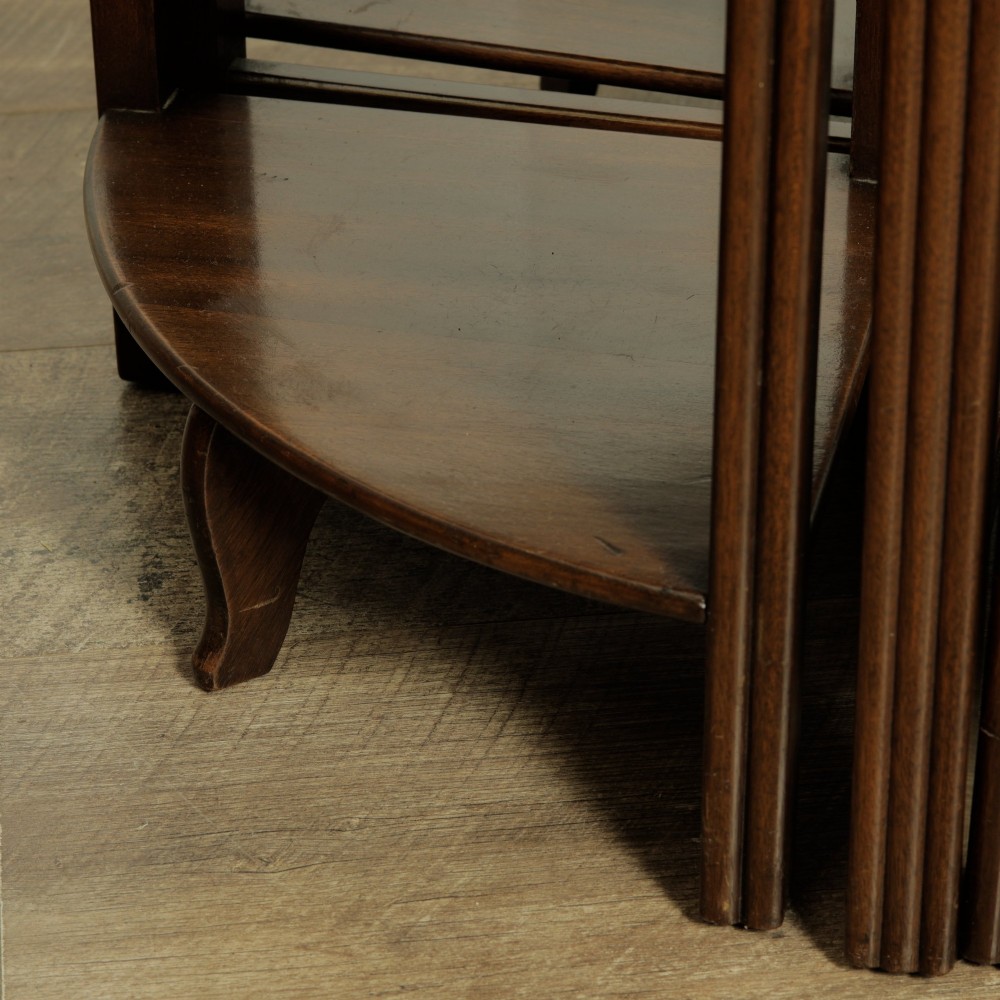 An Edwardian mahogany nest of five circular tables featuring four individual quarter-circle side tables stacked beneath the central round table. View IX