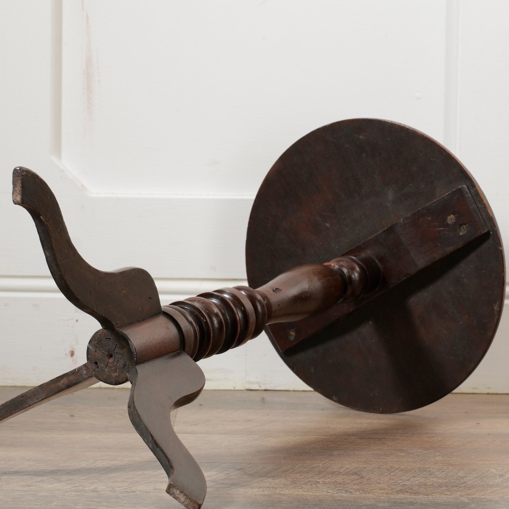 A Victorian dark mahogany pedestal wine table featuring a round top, a turned central column, and three curved tripod legs. View V
