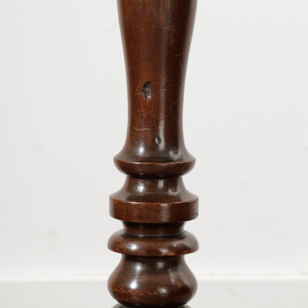 A Victorian dark mahogany pedestal wine table featuring a round top, a turned central column, and three curved tripod legs. View VII