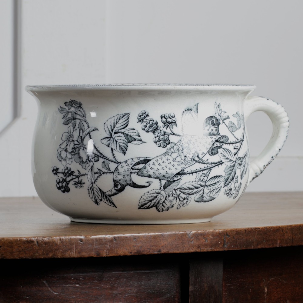 An early 20th-century white ceramic wash set featuring a large ewer and two chamber pots decorated with a black botanical blackberry transferware pattern. View V