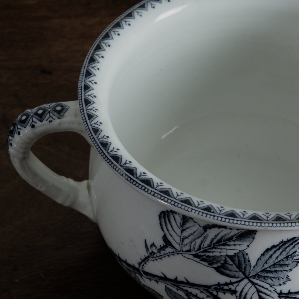 An early 20th-century white ceramic wash set featuring a large ewer and two chamber pots decorated with a black botanical blackberry transferware pattern. View VI