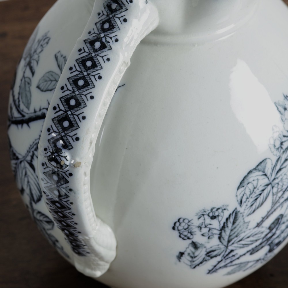 An early 20th-century white ceramic wash set featuring a large ewer and two chamber pots decorated with a black botanical blackberry transferware pattern. View VII