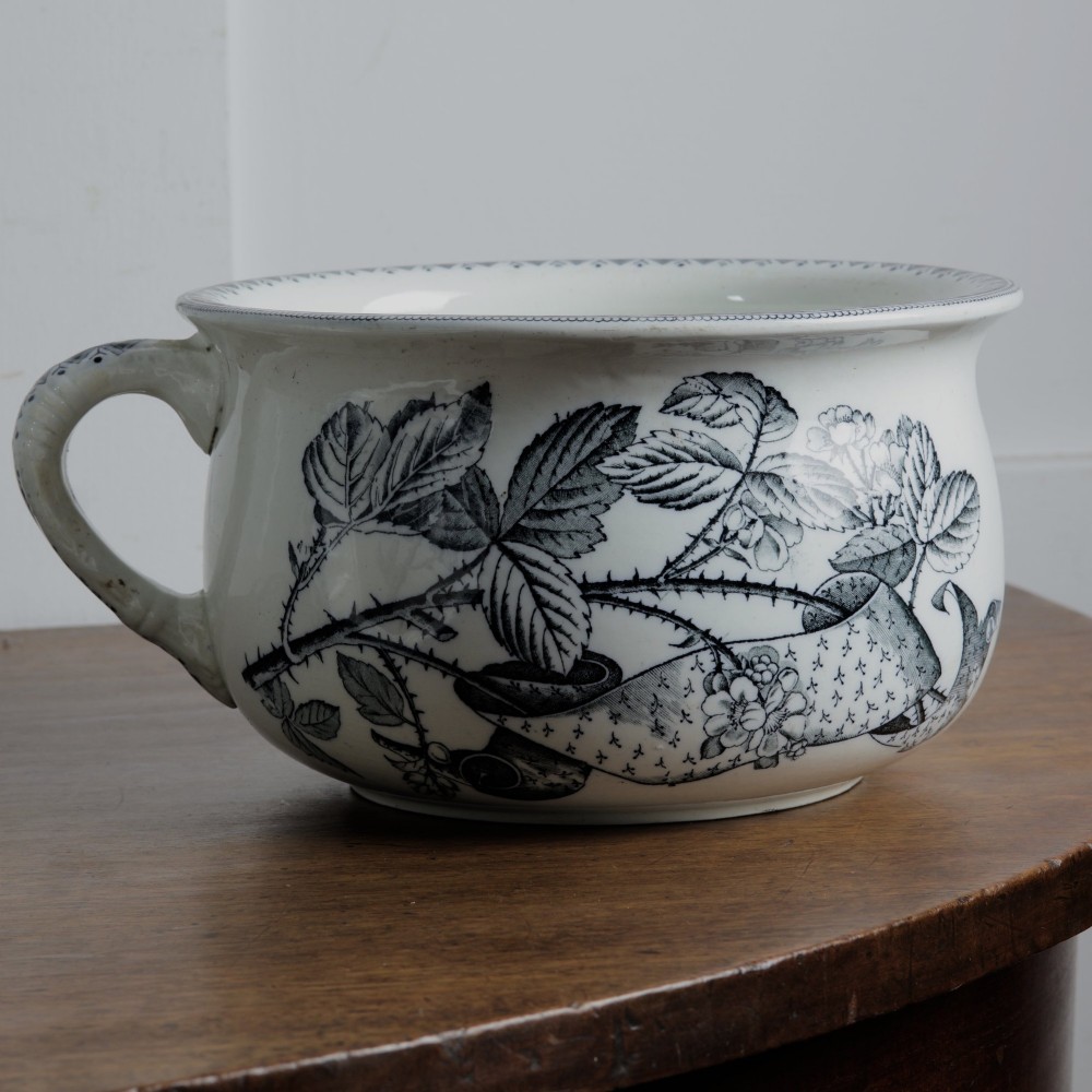 An early 20th-century white ceramic wash set featuring a large ewer and two chamber pots decorated with a black botanical blackberry transferware pattern. View IX
