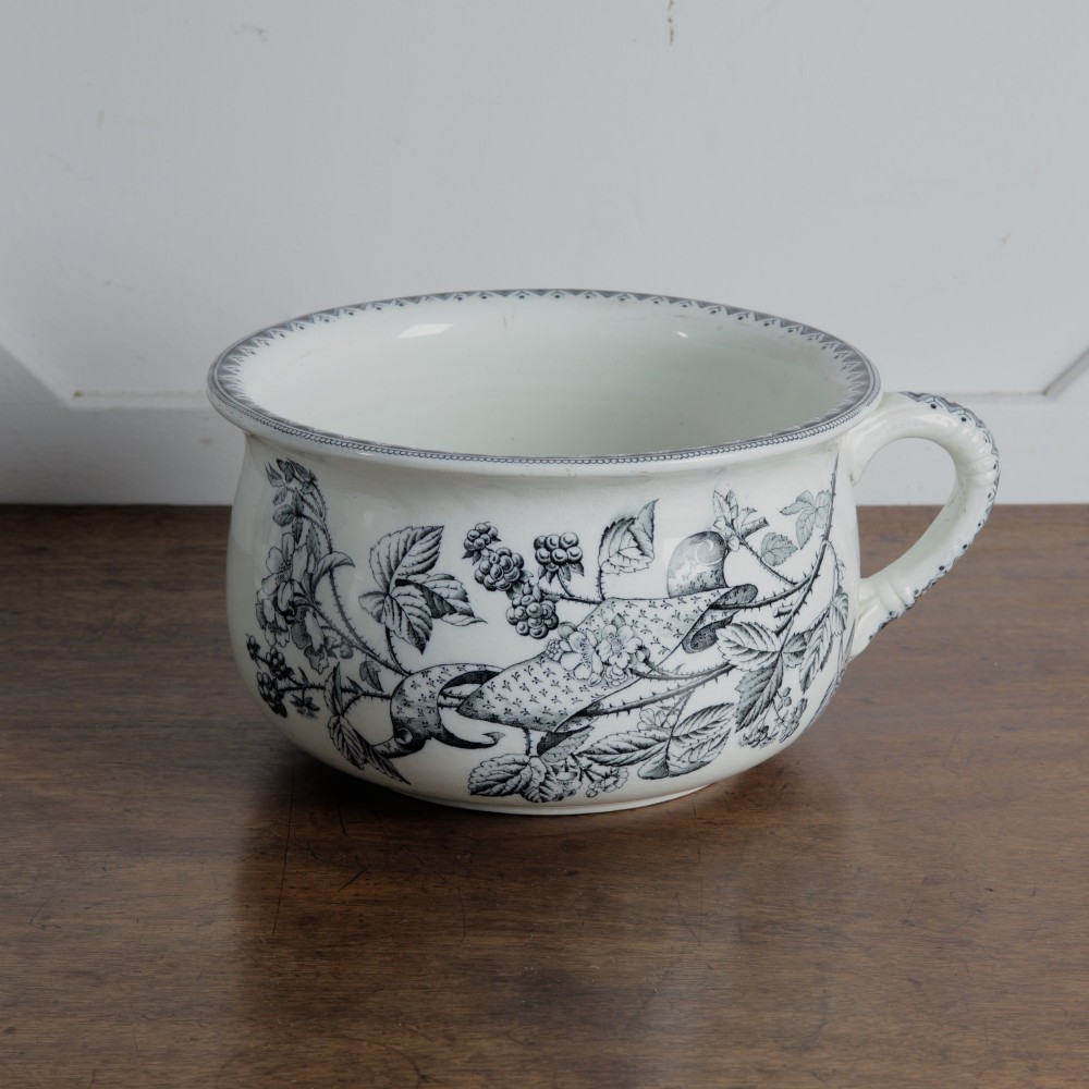 An early 20th-century white ceramic wash set featuring a large ewer and two chamber pots decorated with a black botanical blackberry transferware pattern. View XII