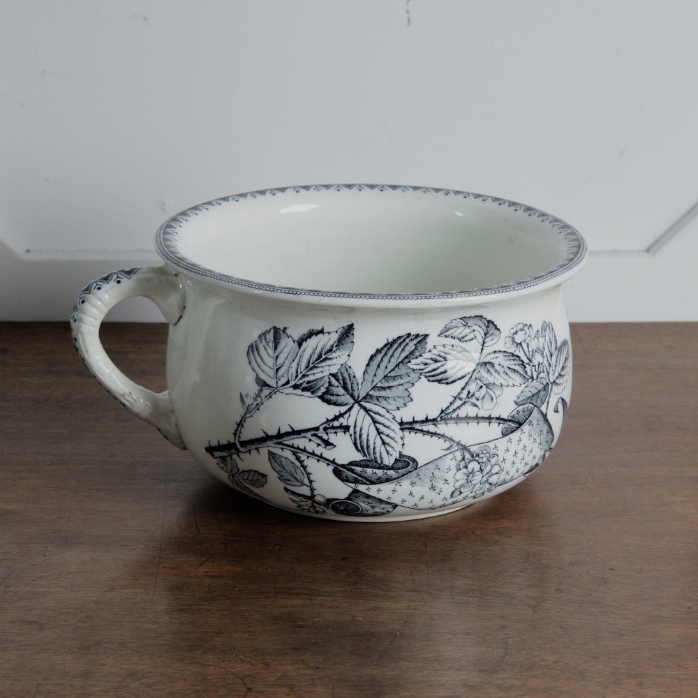 An early 20th-century white ceramic wash set featuring a large ewer and two chamber pots decorated with a black botanical blackberry transferware pattern. View XIII