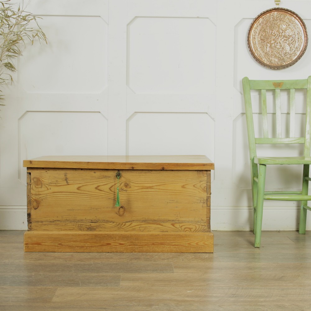 A rectangular Victorian pitch pine storage trunk featuring visible dovetail joinery, an iron keyhole escutcheon, metal side handles, and a plinth base. View IV