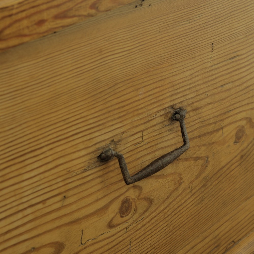 A rectangular Victorian pitch pine storage trunk featuring visible dovetail joinery, an iron keyhole escutcheon, metal side handles, and a plinth base. View V