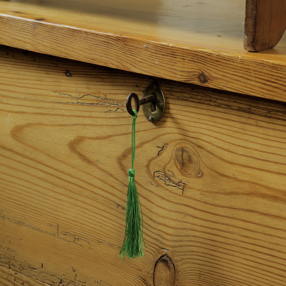 A rectangular Victorian pitch pine storage trunk featuring visible dovetail joinery, an iron keyhole escutcheon, metal side handles, and a plinth base. View VII