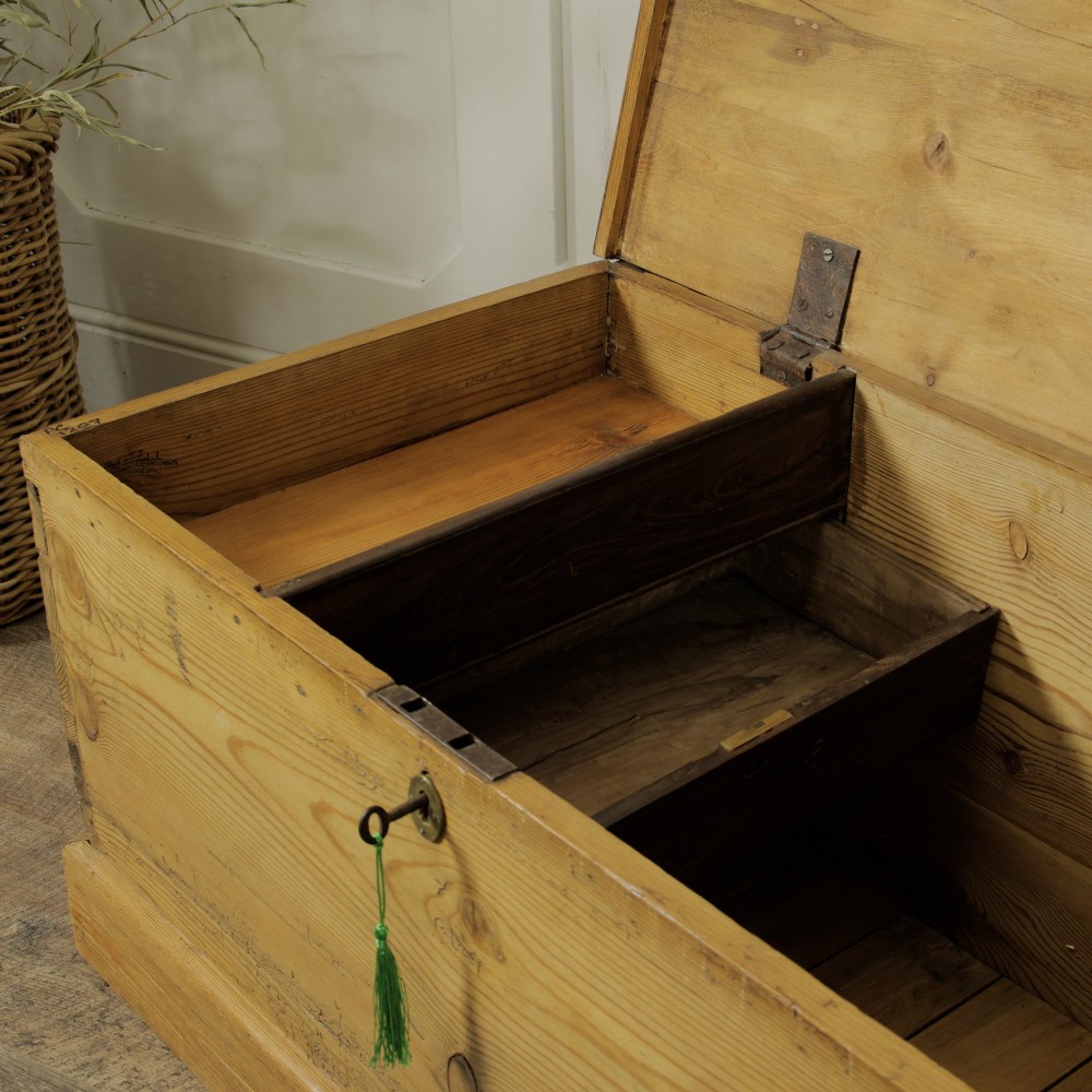A rectangular Victorian pitch pine storage trunk featuring visible dovetail joinery, an iron keyhole escutcheon, metal side handles, and a plinth base. View XI