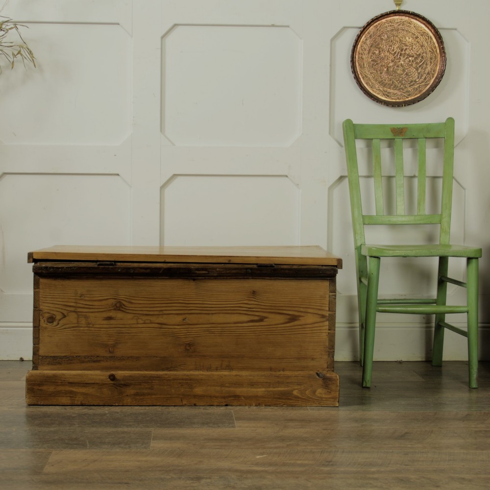 A rectangular Victorian pitch pine storage trunk featuring visible dovetail joinery, an iron keyhole escutcheon, metal side handles, and a plinth base. View XIV