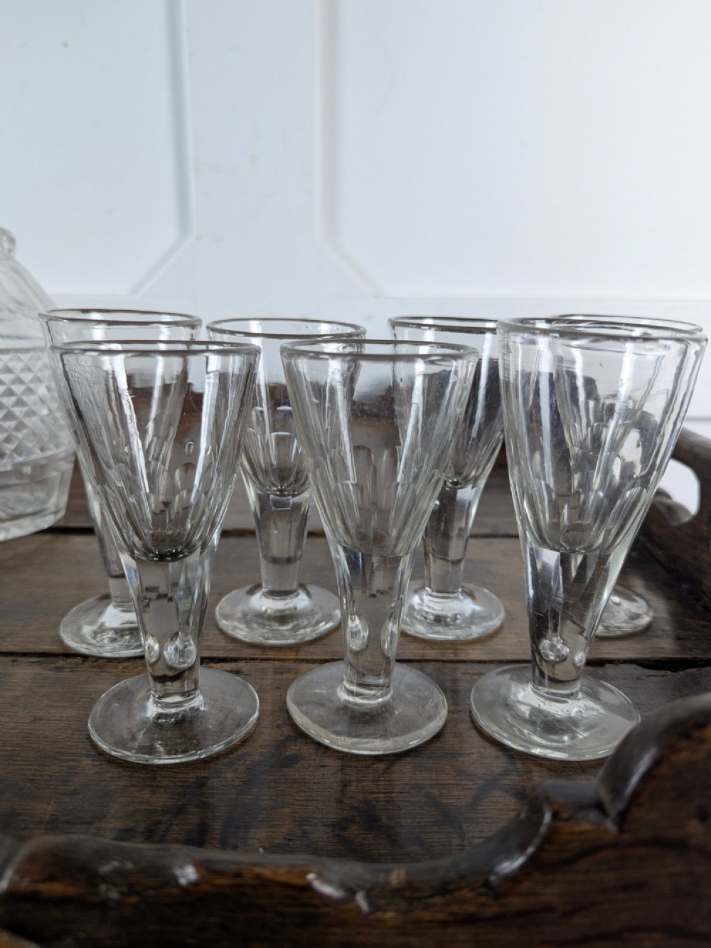 A set of seven clear Victorian glass sherry flutes featuring thumb-cut facet details on conical bowls and short turned stems. View II