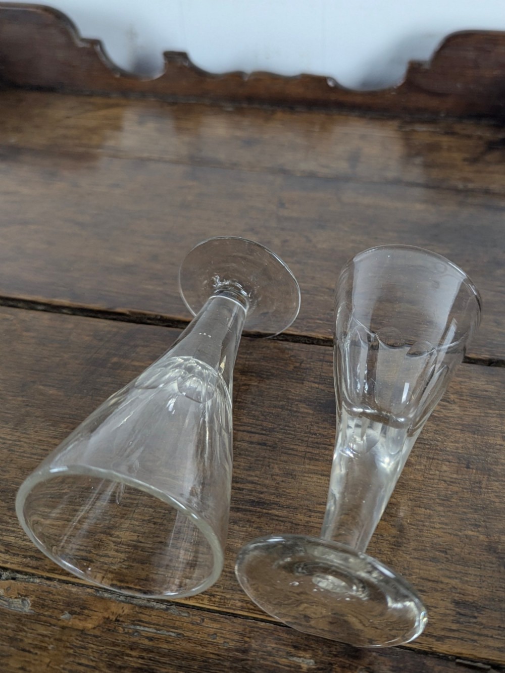 A set of seven clear Victorian glass sherry flutes featuring thumb-cut facet details on conical bowls and short turned stems. View VI