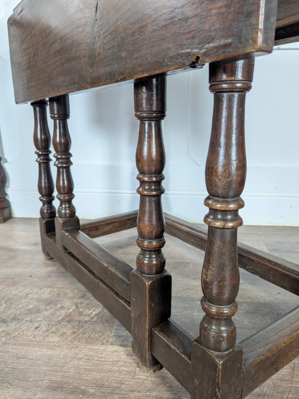 An eighteenth-century dark oak gateleg table with drop leaves, turned legs, stretchers, and a single end drawer. View V