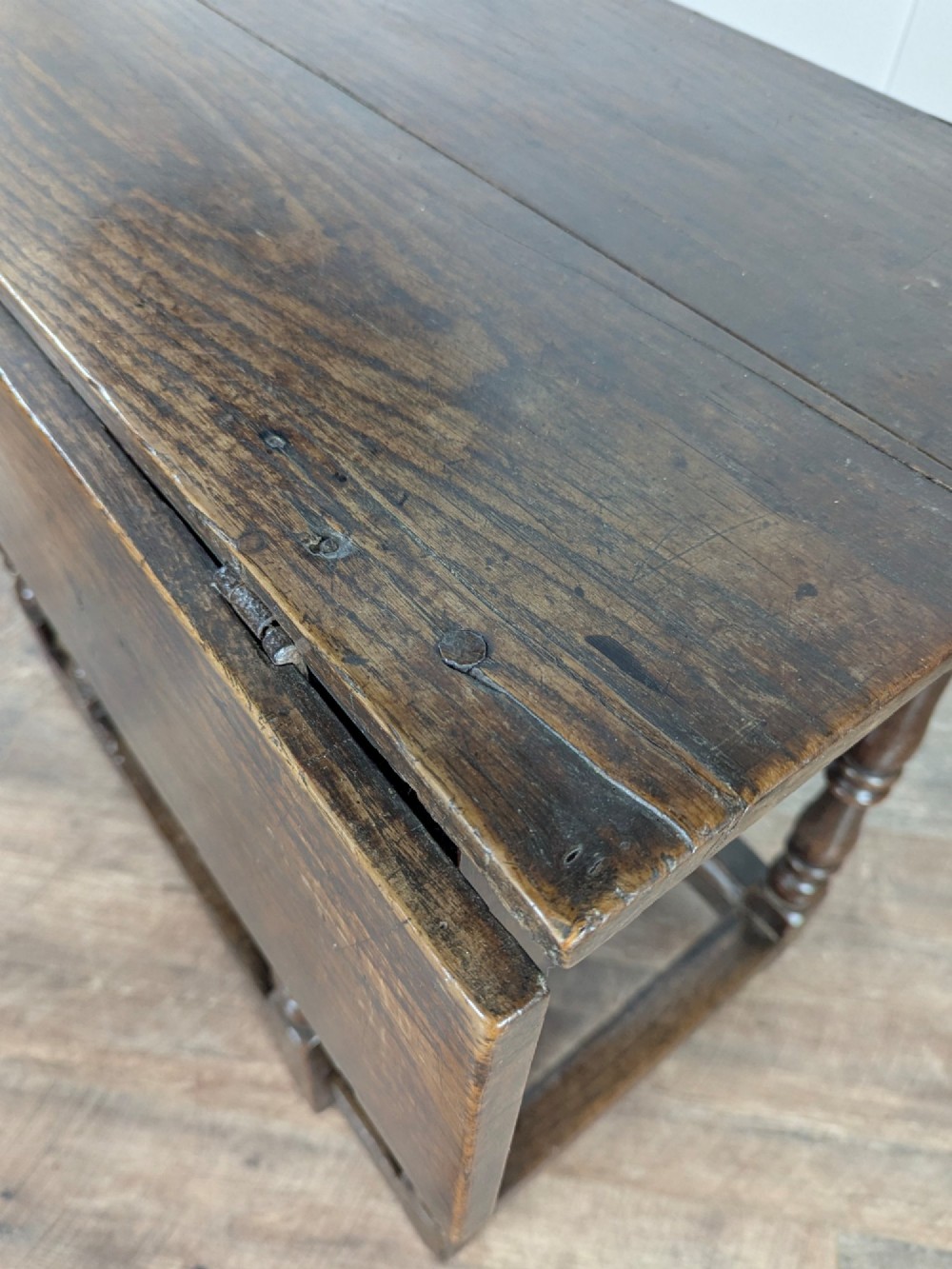 An eighteenth-century dark oak gateleg table with drop leaves, turned legs, stretchers, and a single end drawer. View IX