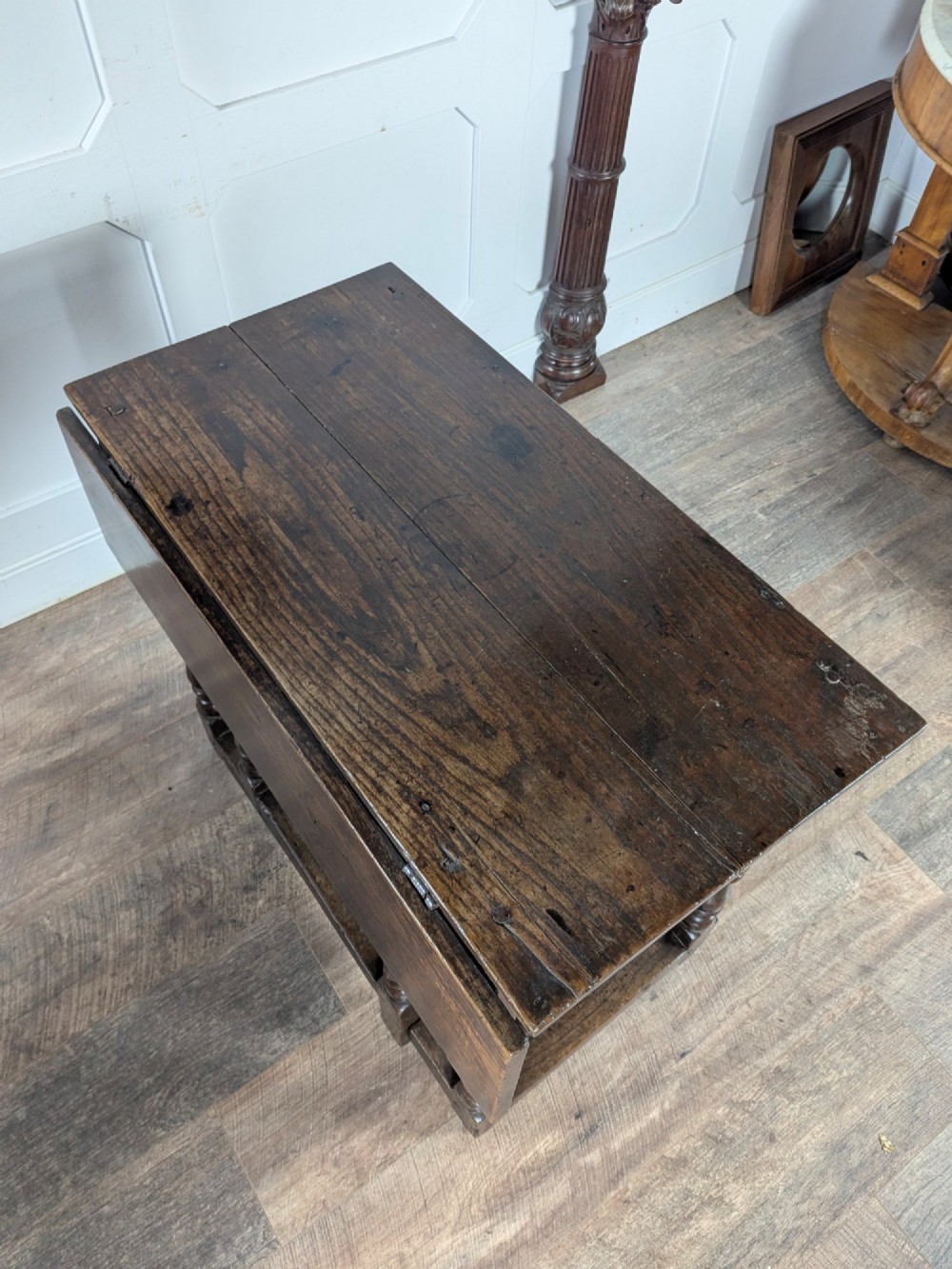 An eighteenth-century dark oak gateleg table with drop leaves, turned legs, stretchers, and a single end drawer. View X