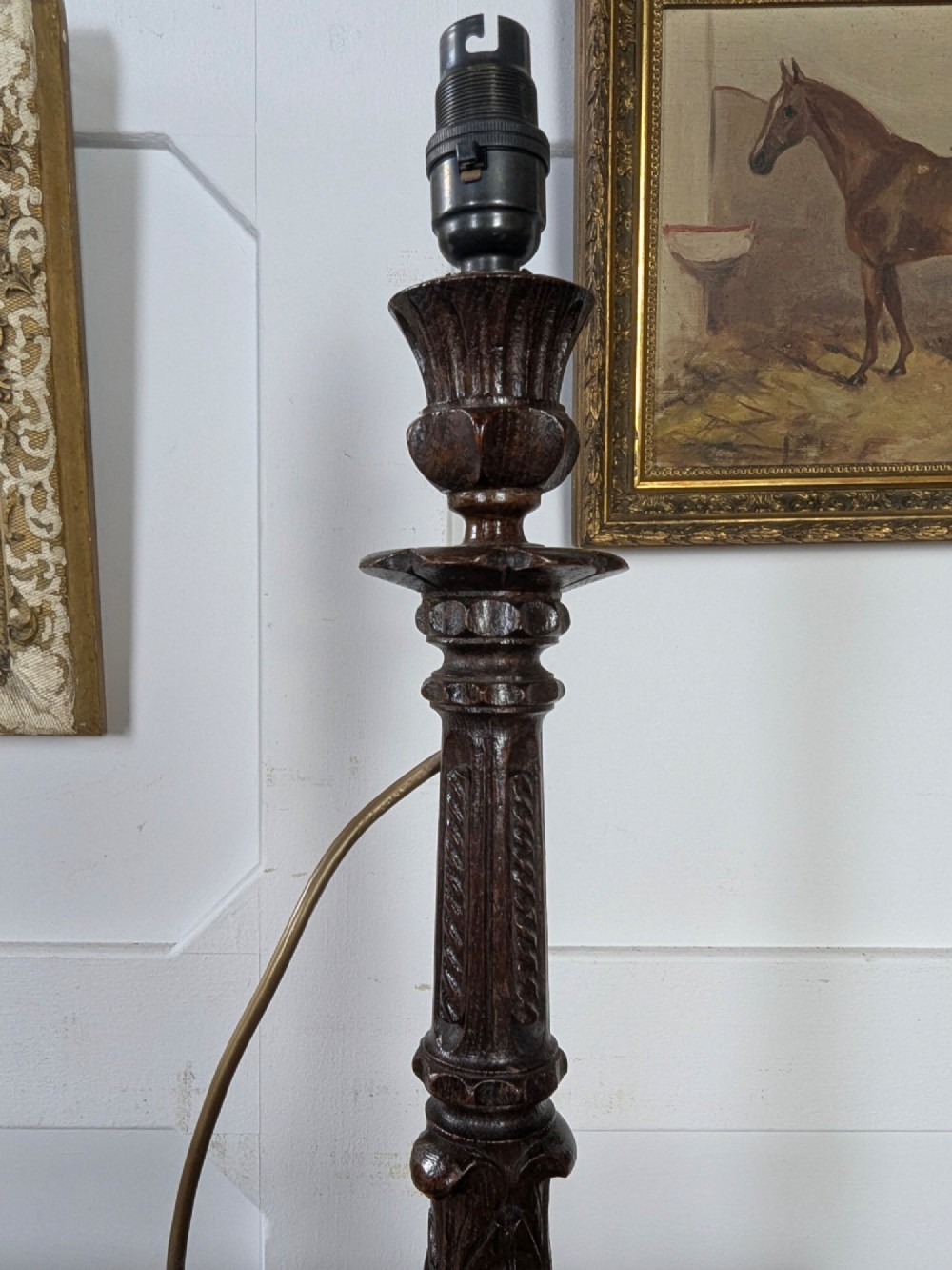 A late Victorian carved dark oak candlestick table lamp base featuring detailed acanthus leaf carvings and an exposed filament bulb. View III