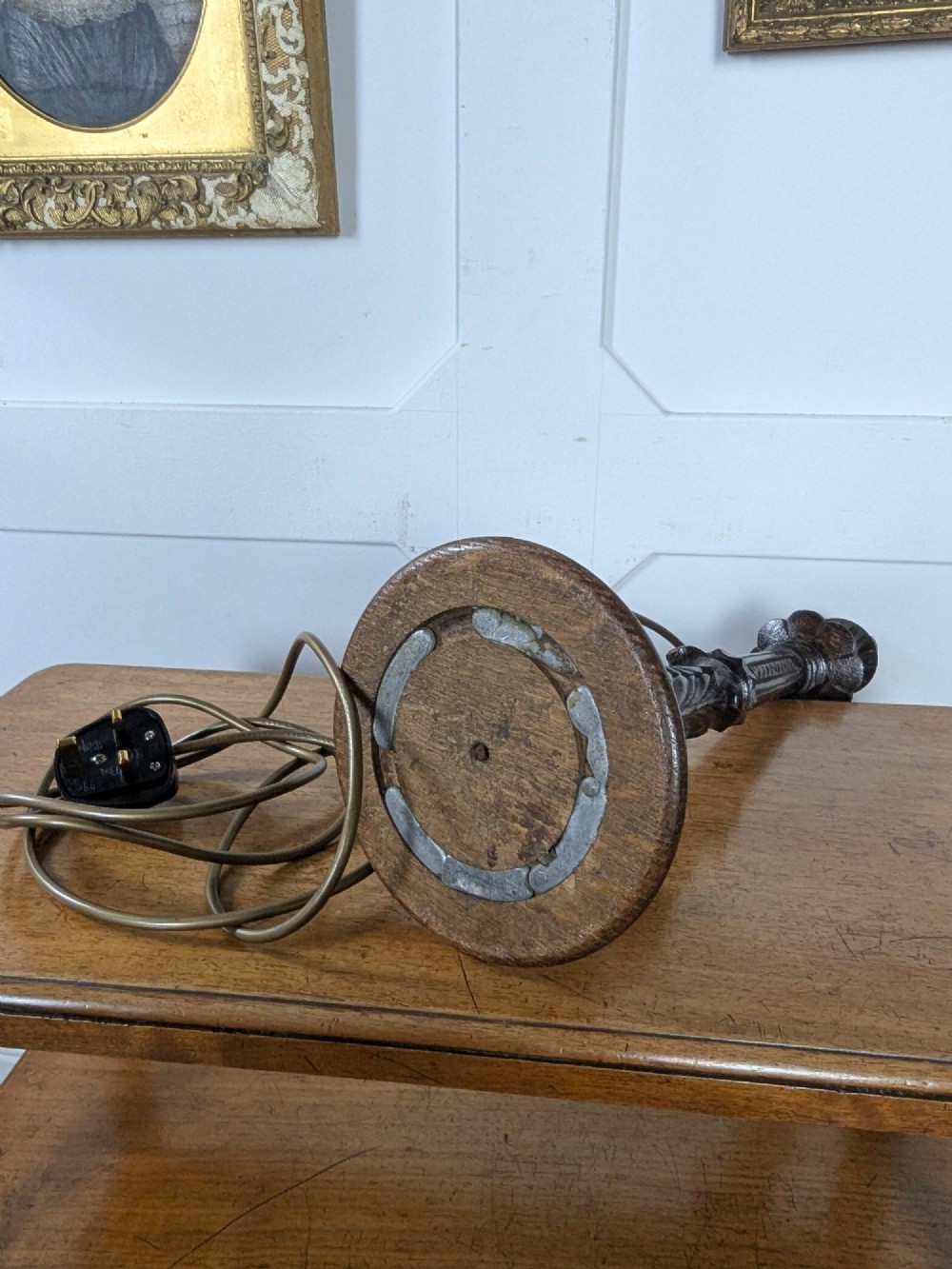 A late Victorian carved dark oak candlestick table lamp base featuring detailed acanthus leaf carvings and an exposed filament bulb. View VI