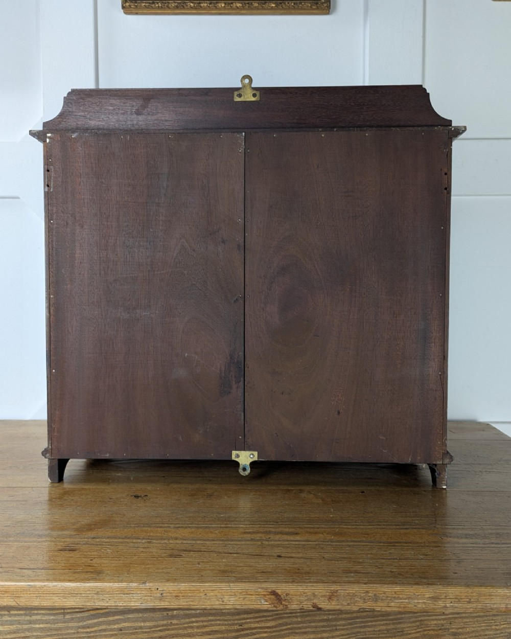 A late nineteenth-century warm brown wooden smokers cabinet featuring an open shelf over two drawers on the left, a single inlaid door on the right, and brass hardware. View IV