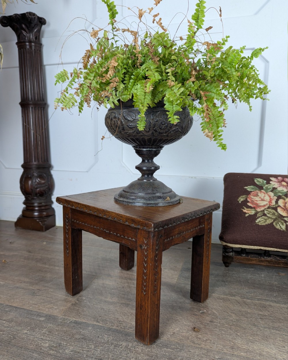 A rectangular dark oak low stool featuring hand-carved notch decorations along the apron and straight legs. View II
