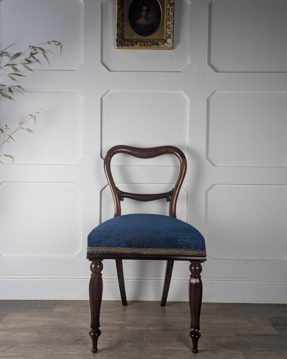 A Victorian rosewood side chair with a curved kidney backrest, turned front legs, and a navy blue velvet upholstered seat. View IV