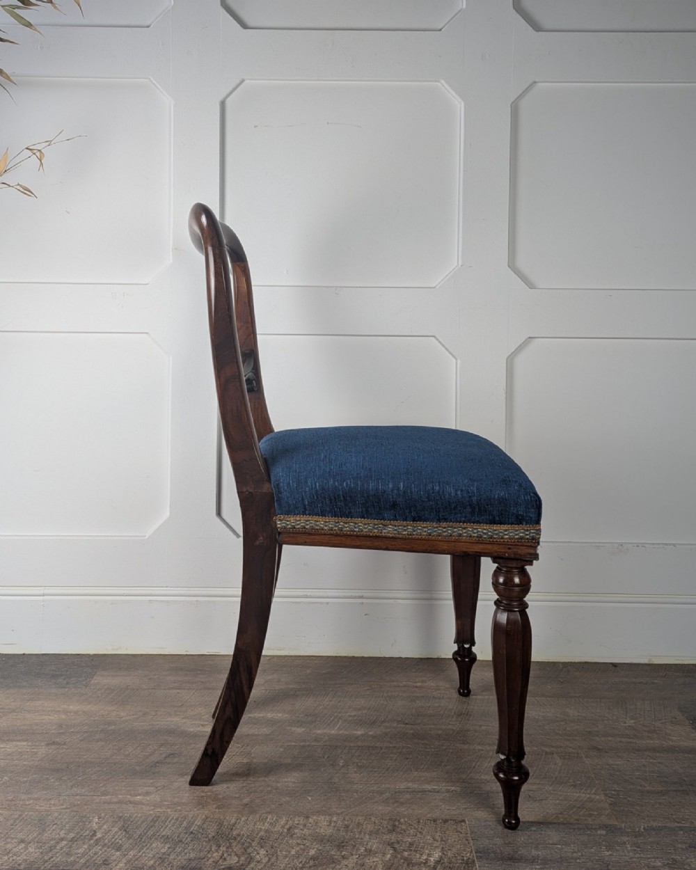 A Victorian rosewood side chair with a curved kidney backrest, turned front legs, and a navy blue velvet upholstered seat. View V