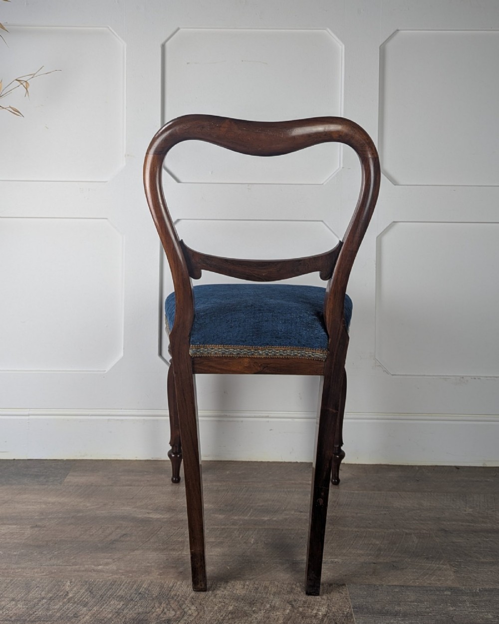 A Victorian rosewood side chair with a curved kidney backrest, turned front legs, and a navy blue velvet upholstered seat. View VI