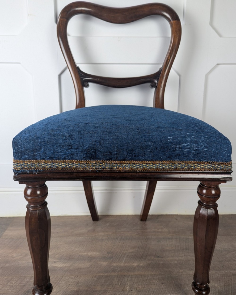A Victorian rosewood side chair with a curved kidney backrest, turned front legs, and a navy blue velvet upholstered seat. View VII